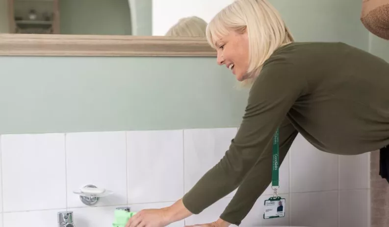 A care professional assisting a senior with daily tasks as part of a care needs assessment evaluation.