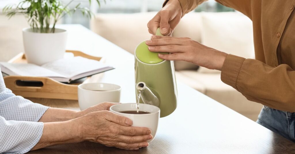 Adult child talking about loneliness with an elderly parent at home during a meaningful conversation to promote emotional wellbeing and reduce loneliness.