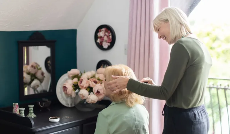 A respite care worker assisting an elderly person at home, offering companionship and support.